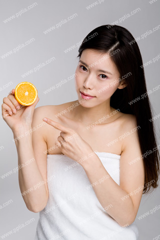 샤워 타올을 걸친 여성이 오렌지 들고 있는 모습 이미지 미리보기