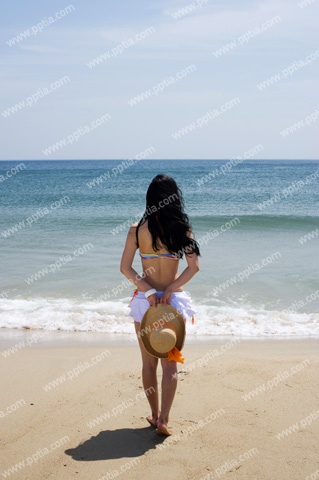 해변가에 비키니 여성이 모자들고 있는 모습 이미지 미리보기