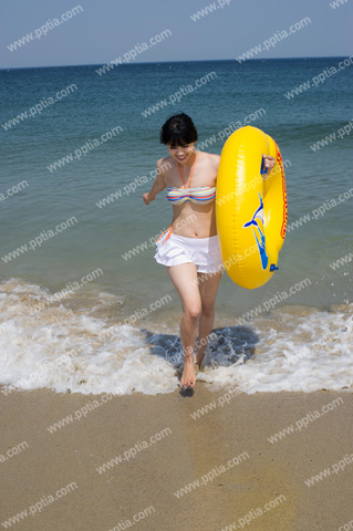 해변가에 튜브 들고 있는 비키니 여성 이미지 미리보기