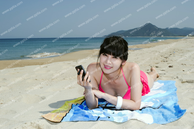 해변가에 휴대폰 들고 있는 비키니 여성 이미지 미리보기
