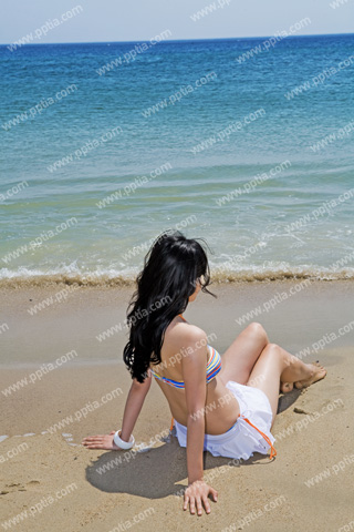 해변가에 비키니 여성이 앉아있는 모습 이미지 미리보기