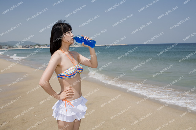 해변가에 비키니 여성이 음료수 마시는 모습 이미지 미리보기