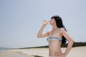 해변가에 비키니 여성이 물 마시는 모습 템플릿